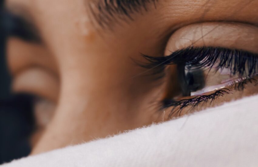 A closeup on a person's tearful eye.